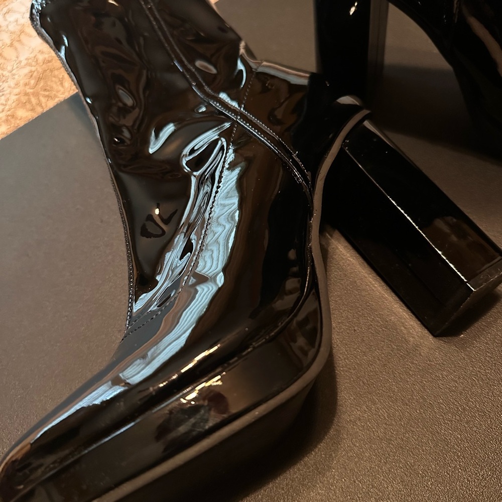 Black patent leather Chelsea boot with a high heel